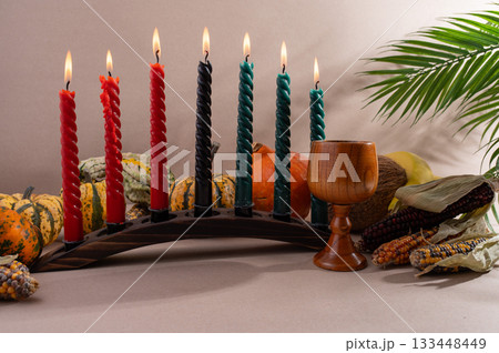 Happy Kwanzaa. Seven candles red, black and green on a natural wooden background. Harvest and gifts. Symbols of African heritage. Happy Kwanzaa. Seven candles red, black and green on a natural wooden background. Harvest and gifts. Symbols of African heritage. 133448449