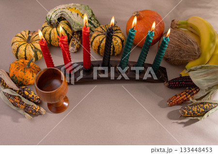 Happy Kwanzaa. Seven candles red, black and green on a natural wooden background. Harvest and gifts. Symbols of African heritage. Happy Kwanzaa. Seven candles red, black and green on a natural wooden background. Harvest and gifts. Symbols of African heritage. 133448453