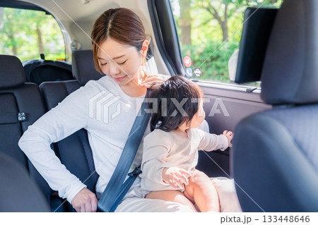 タクシーでシートベルトをする子連れのお母さん タクシーでシートベルトをする子連れのお母さん 133448646