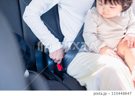 タクシーでシートベルトをする子連れのお母さん タクシーでシートベルトをする子連れのお母さん 133448647