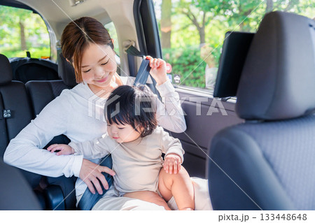 タクシーでシートベルトをする子連れのお母さん タクシーでシートベルトをする子連れのお母さん 133448648