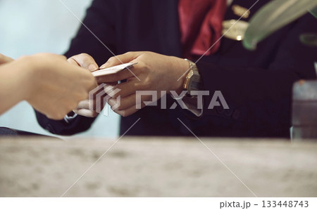 Two hands exchange a business card and transactions, highlighting networking, professional contact, and collaboration between individuals 133448743