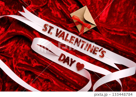 Festive background with the words St. Valentine's Day with red velvet and white ribbon. 133448784