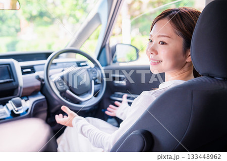 自動運転の車で手放し運転をする若い女性 自動運転の車で手放し運転をする若い女性 133448962