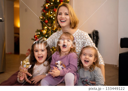 Joyful holiday gathering with family around a festive tree Joyful holiday gathering with family around a festive tree 133449122