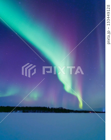 Aurora Borealis in Scandinavia. Northern lights over frozen lake and forest. Starry sky Aurora Borealis in Scandinavia. Northern lights over frozen lake and forest. Starry sky 133449128