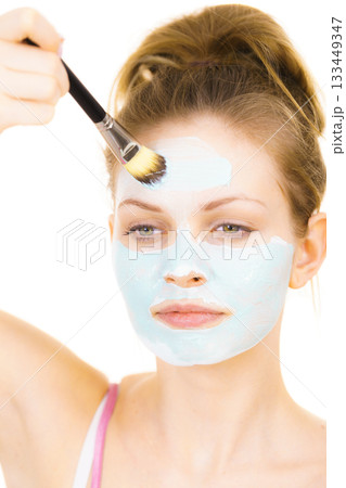 Girl apply green mud mask to face Girl apply green mud mask to face 133449347