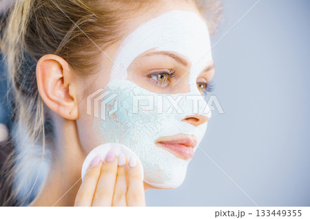 Girl removes dry white mud mask 133449355