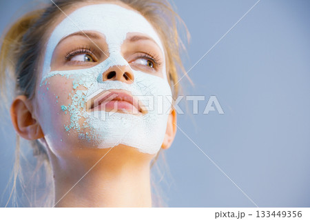 Girl removes dry white mud mask Girl removes dry white mud mask 133449356