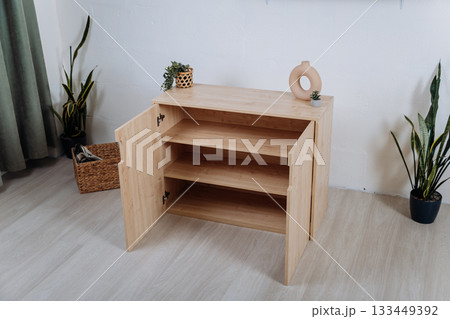 Wooden storage cabinet with open doors and adjustable shelves in modern interior 133449392