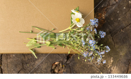 Wildflowers on brown gift box on rustic wooden surface 133449686