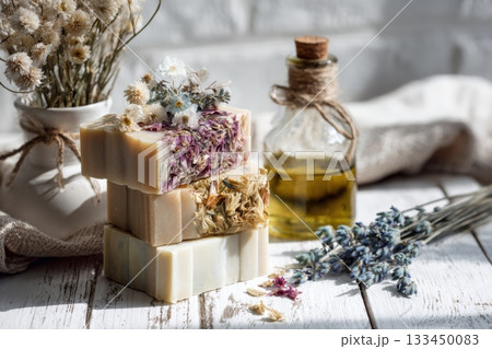 Aesthetic Display of Handmade Herbal Soaps with Natural Ingredients and Decorative Elements in a Warm, Rustic Setting 133450083