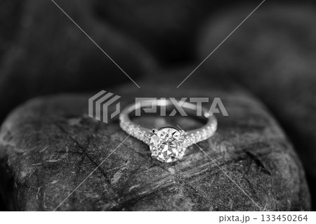 A diamond ring is on a rock 133450264