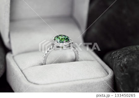 A green and white ring is in a white box 133450265