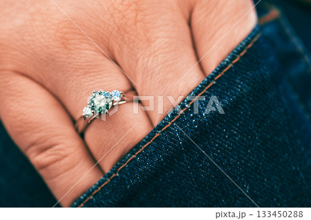 A person is wearing a ring with three stones on it A person is wearing a ring with three stones on it 133450288