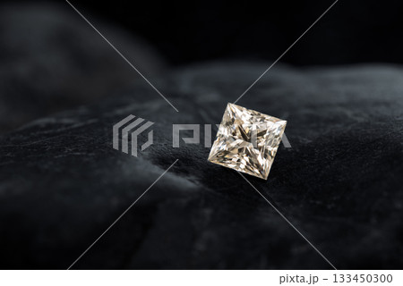 A diamond is sitting on a black surface 133450300