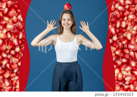 Beautiful young happy woman holding pomegranate fruit on her head Beautiful young happy woman holding pomegranate fruit on her head 133450325
