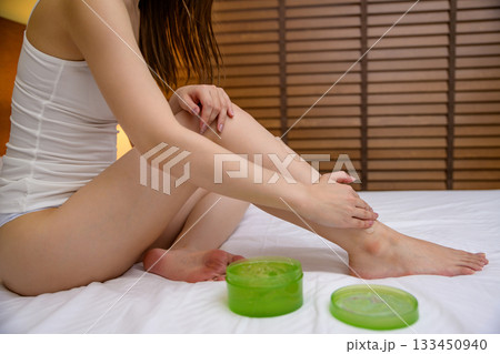 寝る前にベッドでボディジェルを脚に塗る下着姿の若いスレンダーな女性 フットケア 寝る前にベッドでボディジェルを脚に塗る下着姿の若いスレンダーな女性 フットケア 133450940