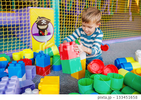 Child Playing with Colorful Building Blocks in Indoor Playground Child Playing with Colorful Building Blocks in Indoor Playground 133451658