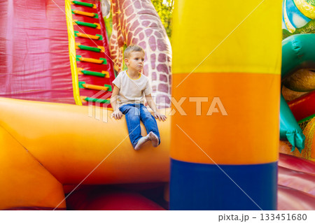 Child Enjoying a Colorful Inflatable Playground Adventure Child Enjoying a Colorful Inflatable Playground Adventure 133451680