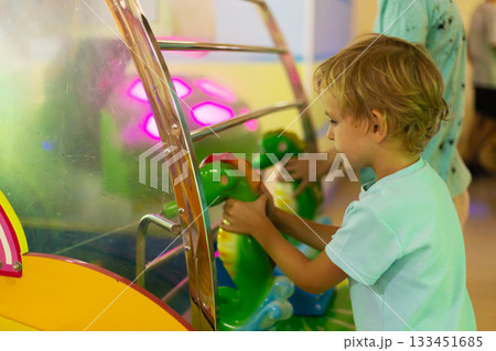 Child Enjoying Arcade Game with Colorful Lights 133451685
