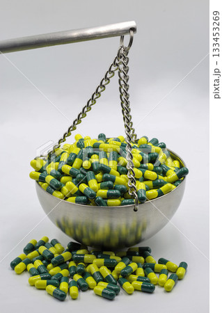 Capsules on balance scale symbolizing medical weight 133453269