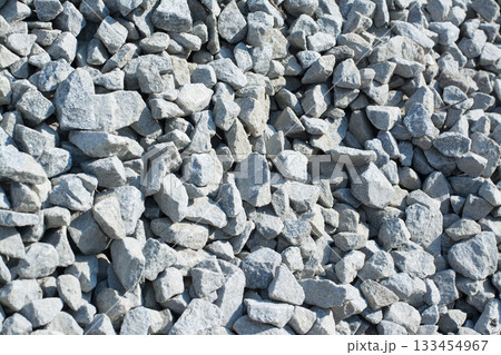 Background of crushed stone against a sun in a pile. Material for road construction Background of crushed stone against a sun in a pile. Material for road construction 133454967
