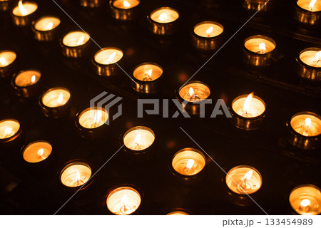 Prayer candles in rows in a church Prayer candles in rows in a church 133454989