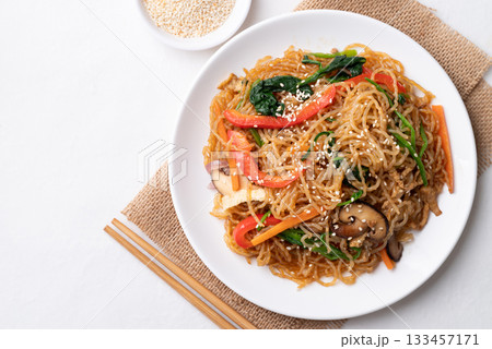 Japchae, Korean stir fried glass noodles with vegetables, pork, soy sauce and sesame oil 133457171