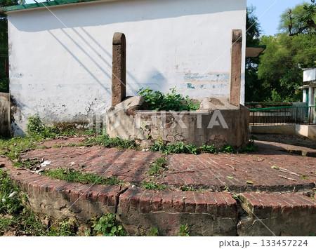 Historic, old traditional water well without water in well, everywhere Grass growing in water well 133457224
