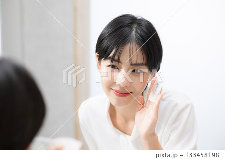メイク落とし(メイクオフ)で肌ケアする笑顔の女性が見せるクレンジング、化粧落としのシーン メイク落とし(メイクオフ)で肌ケアする笑顔の女性が見せるクレンジング、化粧落としのシーン 133458198