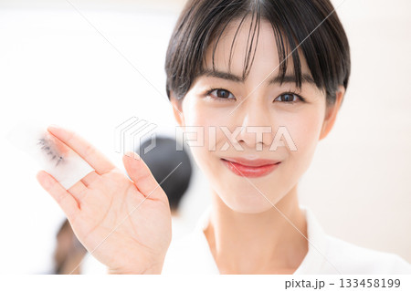 メイク落とし（メイクオフ）で肌ケアする笑顔の女性が見せるクレンジング、化粧落としのシーン　カメラ目線 133458199