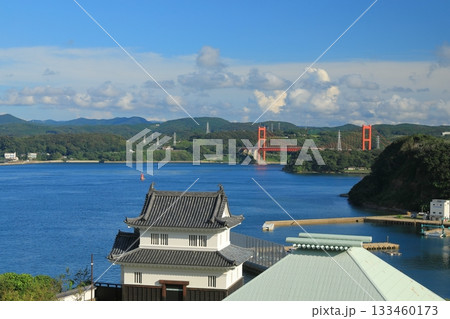 青空の下の平戸城の懐柔櫓と平戸大橋の景色 133460173