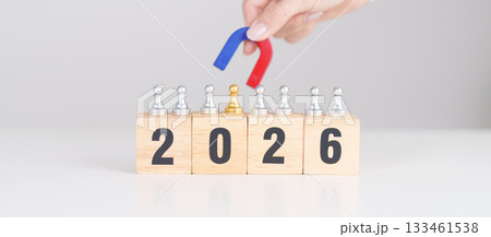 hand holding magnet and pulling man chess figure from the crowd employee with 2026 Year block. Human resource management, Recruitment, Teamwork, strategy, toxic people and leadership Concepts 133461538