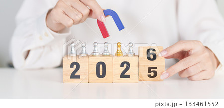 hand holding magnet and pulling man chess figure from the crowd employee with 2026 Year block. Human resource management, Recruitment, Teamwork, strategy, toxic people and leadership Concepts hand holding magnet and pulling man chess figure from the crowd employee with 2026 Year block. Human resource management, Recruitment, Teamwork, strategy, toxic people and leadership Concepts 133461552