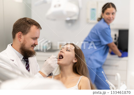 Woman checking her teeth at a dentist appointment Woman checking her teeth at a dentist appointment 133461870