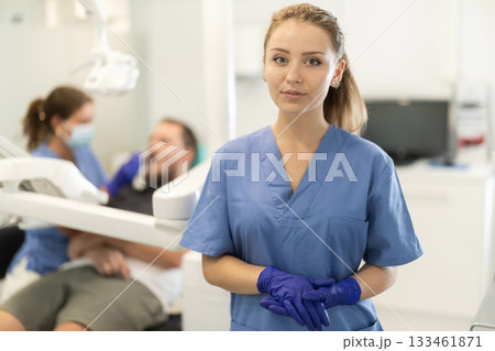 Female dental assistant standing in front of the office Female dental assistant standing in front of the office 133461871