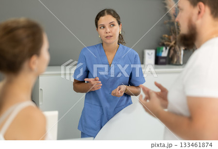 female administrator communicates with clients of a dental clinic 133461874