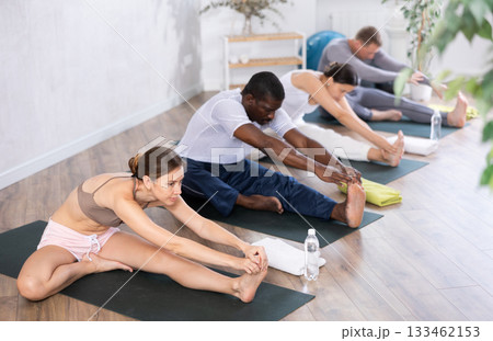 Young woman doing yoga in group in studio Young woman doing yoga in group in studio 133462153