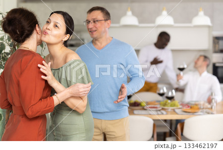 Happy middle-aged pair welcoming a woman at home Happy middle-aged pair welcoming a woman at home 133462197