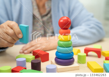 Asian elderly woman patient suffering from dementia learn practical motor skills rehabilitation. 133462263