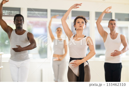 Group of men and women stand in fourth position Group of men and women stand in fourth position 133462310