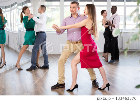 Man and young woman practicing waltz in dancing studio Man and young woman practicing waltz in dancing studio 133462370