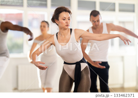 Concentrated women and men rehearsing ballet dance in class Concentrated women and men rehearsing ballet dance in class 133462371