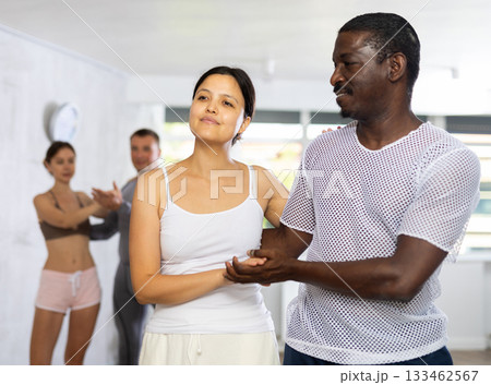 Smiling woman enjoying dance with African american male partner in dancing class Smiling woman enjoying dance with African american male partner in dancing class 133462567