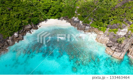A rocky coastline with turquoise waters and sandy beach. Seychelles, Mahe. 133463464