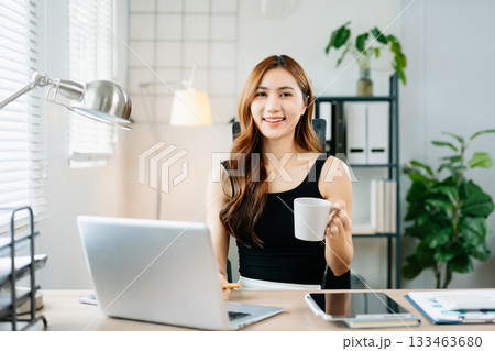 Smiling businesswoman showing thumbs up in bright modern office, symbolizing success, approval, and confidence in professional achievement. Smiling businesswoman showing thumbs up in bright modern office, symbolizing success, approval, and confidence in professional achievement. 133463680