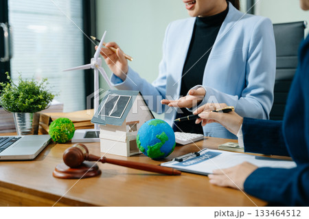 Two professionals plan global sustainability with eco housing, legal contracts, solar energy, and financial investment 133464512