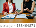 Business documents on office table with smart phone and calculator digital tablet and graph business with social network diagram and two colleagues discussing data 133464871