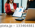 Business documents on office table with smart phone and calculator digital tablet and graph business with social network diagram and two colleagues discussing data 133464881
